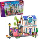 LEGO Friends Liann's familiehuis met een roze huis, blauw dak, skateboardhelling en diverse mini-poppetjes.