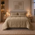 Een taupe teddy dekbed met ruitpatroon en twee bijpassende kussens liggen op een bed.