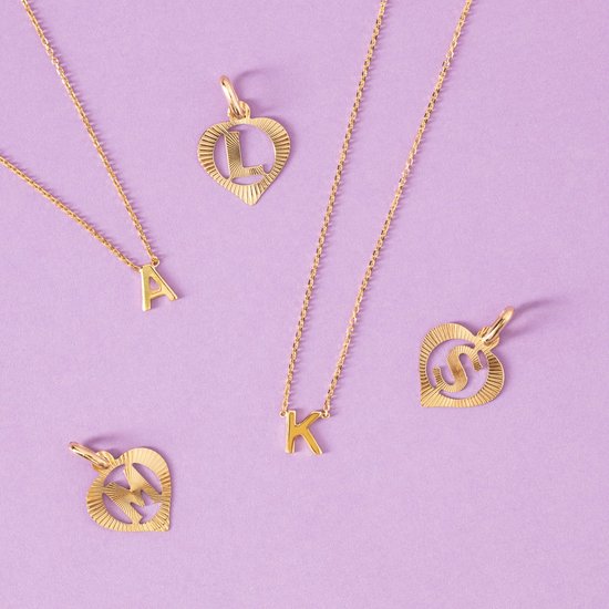 Gouden kettingen en hartvormige hangers met letters A, K, L, M en S op een lila achtergrond.