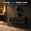 Zwarte Luvonic stekkerdoos stevig aan de muur gemonteerd, met 4 stopcontacten en 3 USB-poorten.