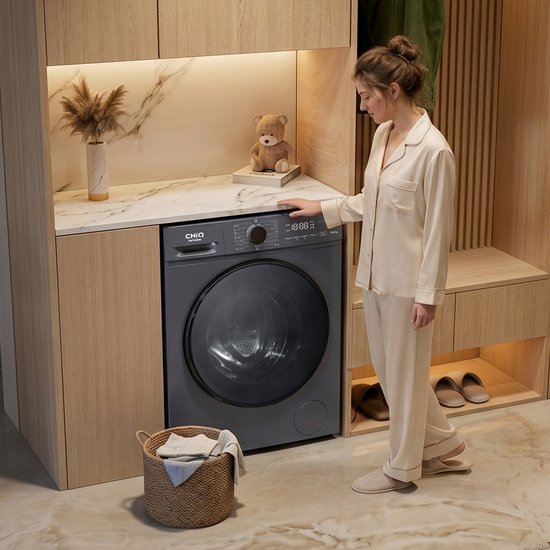 Femme en pyjama près d'un lave-linge CHiQ gris dans une cuisine moderne. Panier de linge à côté de la machine.