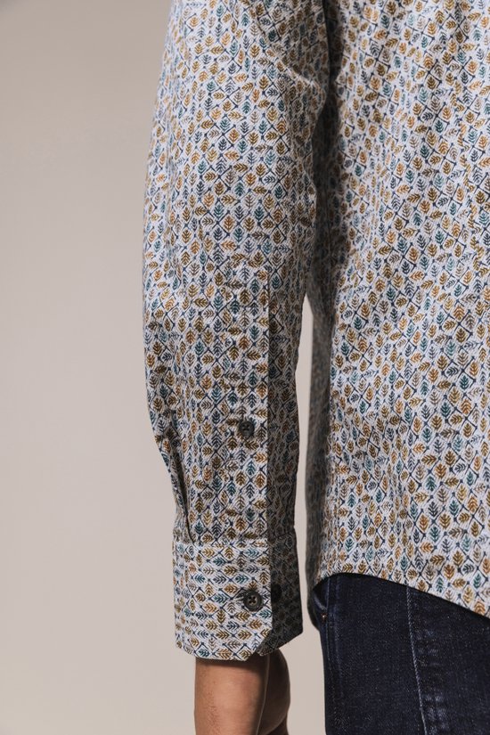 Detailopname van de manchet van een State of Art overhemd met een blauw en okergeel bladmotief.