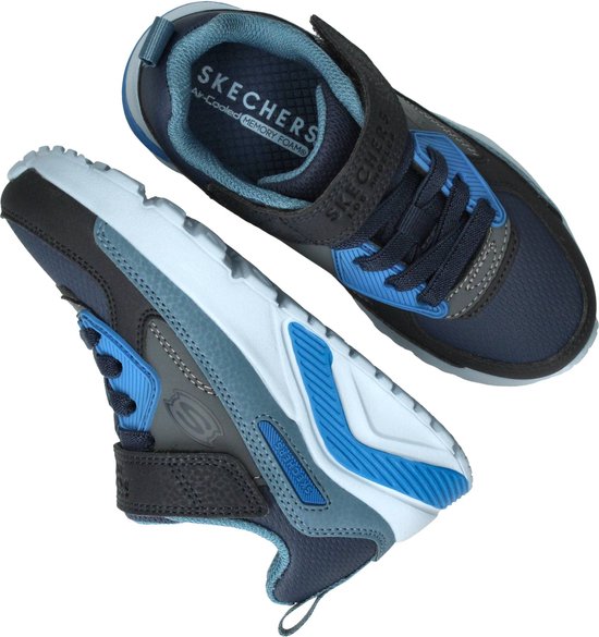 Bovenkant van een paar blauwe Skechers sneakers met klittenband en veters, in navy en grijs.