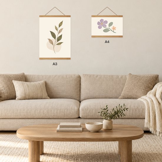 Deux porte-affiches en bois au mur au-dessus d'un canapé beige, formats A3 et A4.