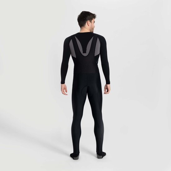 Achteraanzicht van een model in zwarte Rogelli Core fietsbroek, met zichtbare grijze mesh-bretels.