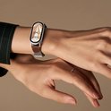 Montre élégante avec cadran doré et bracelet en cuir marron au poignet.