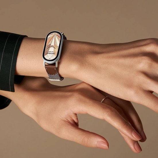 Montre élégante avec cadran doré et bracelet en cuir marron au poignet.