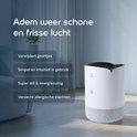 Een witte Vibrix luchtreiniger staat op de vloer in een modern interieur, met tekst over het verwijderen van geurtjes en het verminderen van allergieën.