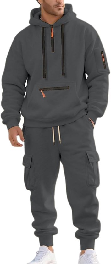 Modèle portant un ensemble de survêtement gris avec pantalon cargo, sweat à capuche zippé et détails orange.
