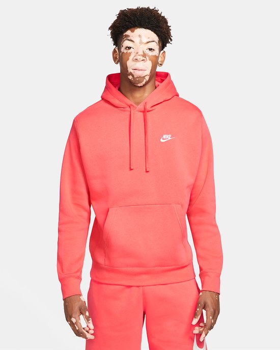 Man in feloranje Nike hoodie met capuchon en Nike logo op de borst.