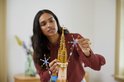 Een vrouw bouwt het LEGO Disney Kasteel, en plaatst een gouden ster-vormig stuk op de top.