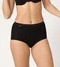 Model draagt een zwarte Sloggi Basic+ maxi slip met kanten rand aan de taille.