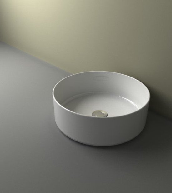 Ronde, glanzend witte opzetwastafel met een zilverkleurige afvoer.