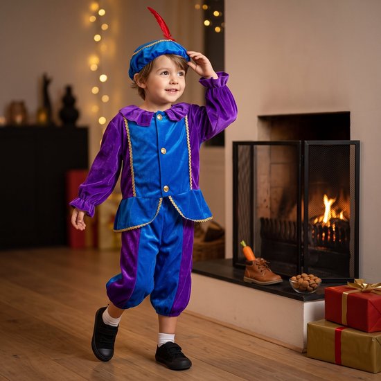 Kind in een paars en blauw fluwelen pietenpak met bijpassende muts met rode veer, staand bij een open haard.