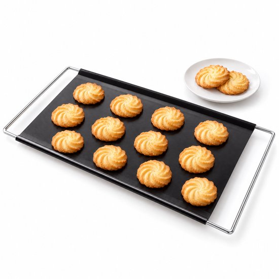 Zwarte, uitschuifbare bakplaat met twaalf koekjes en een extra schaaltje koekjes ernaast.
