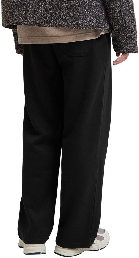 Achteraanzicht van een zwarte sweatbroek met wijde pijpen op een model.