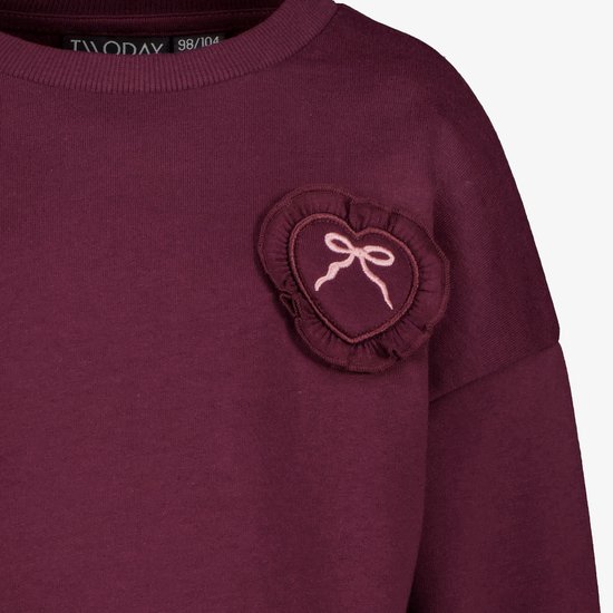 Bordeauxrode sweater met ruches hart patch met strik op de borst.