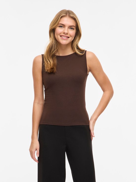 Vrouw, voorkant, lachend, bruine mouwloze top met boothals en zwarte broek