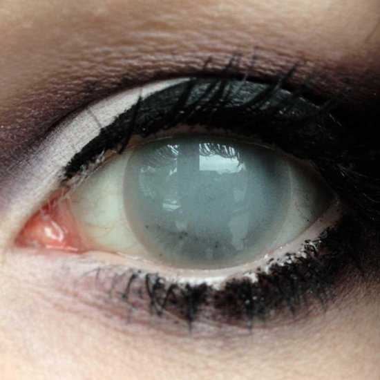 Detailopname van een oog met een dekkende grijze contactlens en zware zwarte oogmake-up.