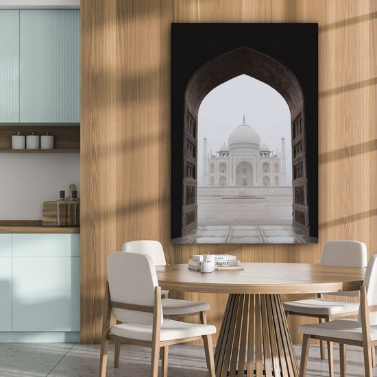 Une peinture du Taj Mahal à travers une arche, vue de l'intérieur.