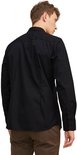 Man in zwart, lang-mouwig button-down overhemd, van achteren gezien.