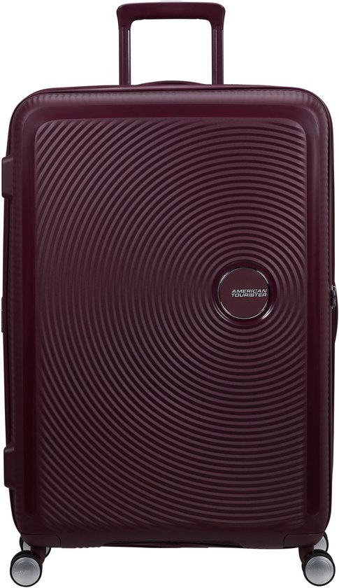 Burgondische koffer met cirkelvormig patroon en 'American Tourister' logo. Uitschuifbaar handvat en vier wielen.