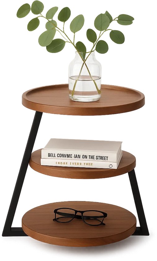 Table d'appoint ronde brune avec cadre noir, un vase avec des branches vertes, des livres et des lunettes.