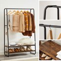 Zwart kledingrek met 2 houten planken, kleding, sjaals, schoenen en hoeden.