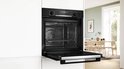 Open Bosch oven met drie bakplaten vol met koekjes, functie 3D hetelucht.