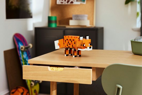 Renard LEGO Minecraft constructible sur un bureau en bois, avec un skateboard à côté.