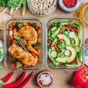 Twee glazen meal prep bakjes: één met kip en groenten, de ander met salade en avocado.