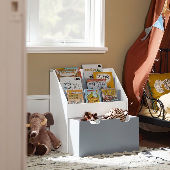 Kinderboekenkast in een kinderkamer met een bed, tent en speelgoedkist.