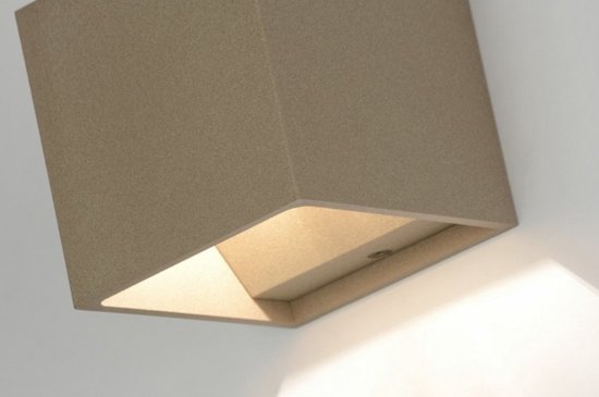 Close-up van de taupekleurige kubusvormige wandlamp, met de open onderkant zichtbaar en een zachte lichtgloed.
