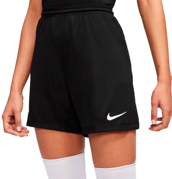Model met zwarte Nike shorts en hoge witte sokken.