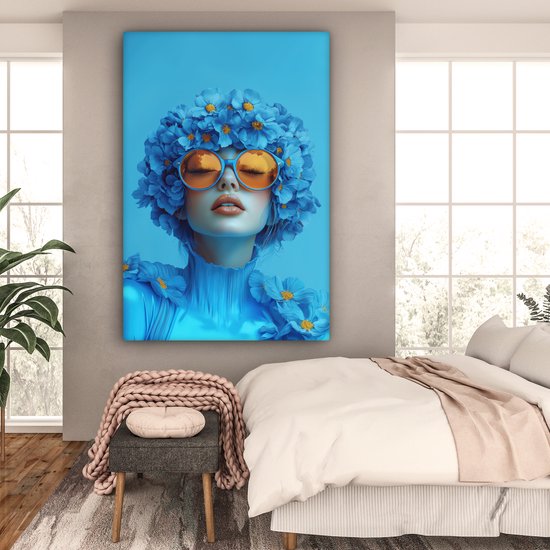 Portrait bleu d'une femme avec des lunettes orange et des fleurs bleues, dans une chambre.