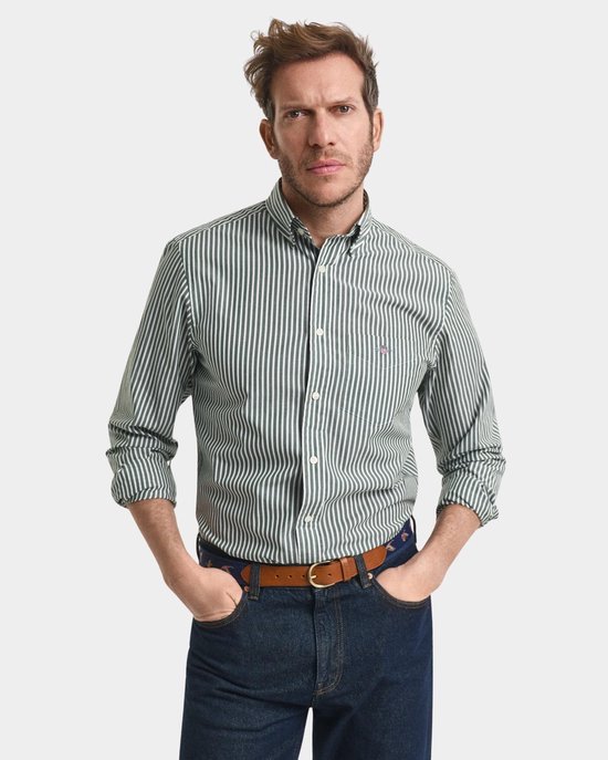 Man met groene gestreepte blouse, spijkerbroek en bruine riem