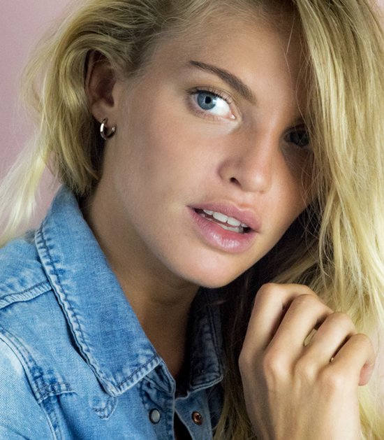 Model met een kleine, gladde zilverkleurige oorring in haar oor.