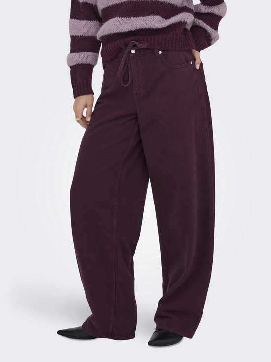 Model met paarse wijde broek met trekkoord en strik. Draagt een gestreepte trui.