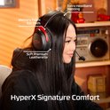 Vrouw met zwarte HyperX headset met rode accenten, met geheugen schuim oorkussens.