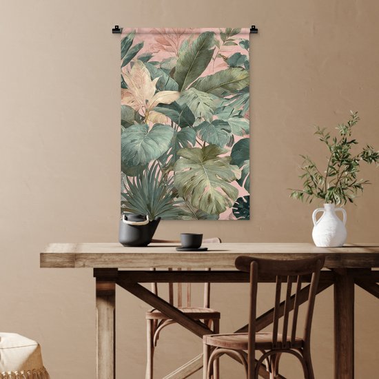 Wandkleed met tropische bladeren in groen en roze tinten, boven een eettafel.