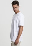 Man in een oversized witte T-shirt, zijaanzicht.