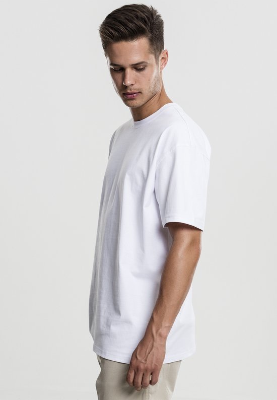 Man in een oversized witte T-shirt, zijaanzicht.