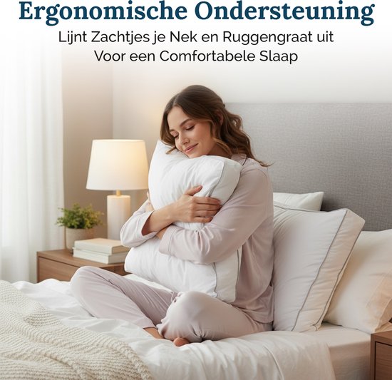 Een vrouw in een lichtroze pyjama zit op een bed en knuffelt een wit kussen. Ze heeft haar ogen gesloten en glimlacht.