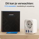 Witte Voomy reisadapter en de zwarte verpakking met blauwe accenten, met "Y712 reistecker" op een houten tafel.