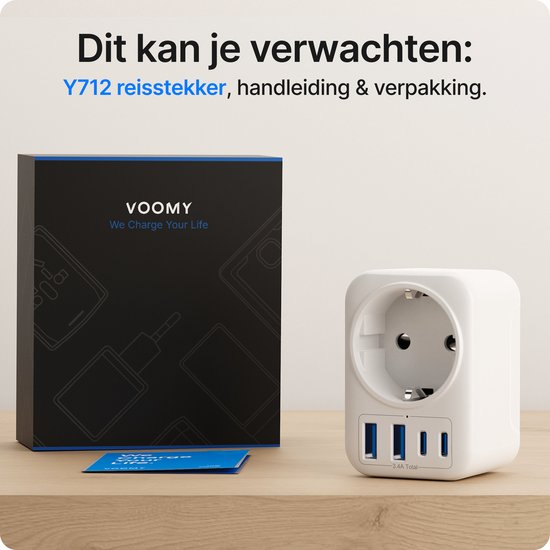 Witte Voomy reisadapter en de zwarte verpakking met blauwe accenten, met "Y712 reistecker" op een houten tafel.