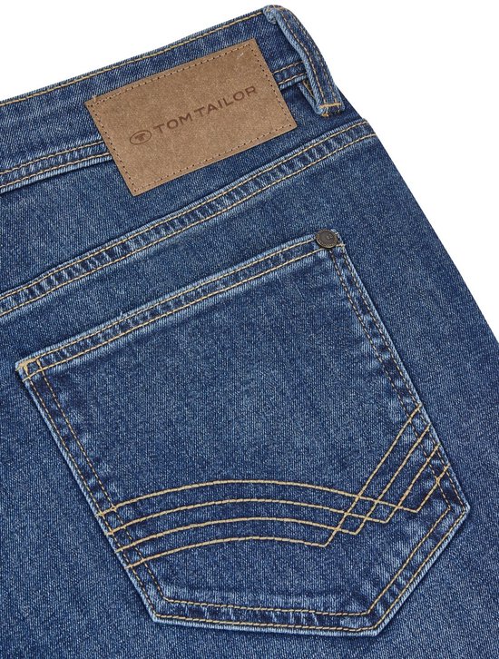 Achterkant van blauwe jeans met bruin Tom Tailor label en gele stiksels op de zakken.