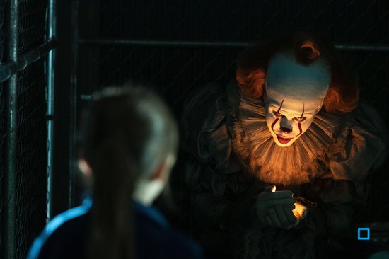 Clown met fel verlicht gezicht, kijkt naar een jongen die een lucifer vasthoudt.