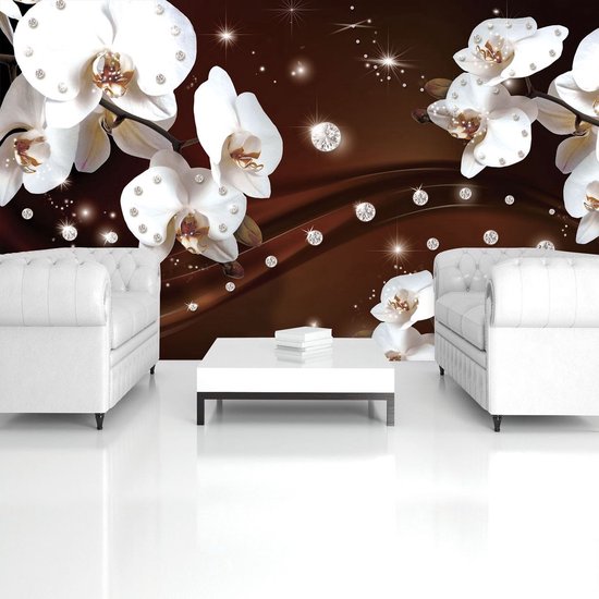 Deux fauteuils blancs avec une table basse blanche entre eux, sur un fond brun orné d'orchidées et de diamants.
