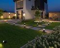 Moderne tuin met een huis, terras, tuinpadverlichting en gazon met paadverlichting.