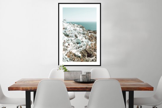 Maison blanche avec mer bleue en arrière-plan, dans un cadre noir.